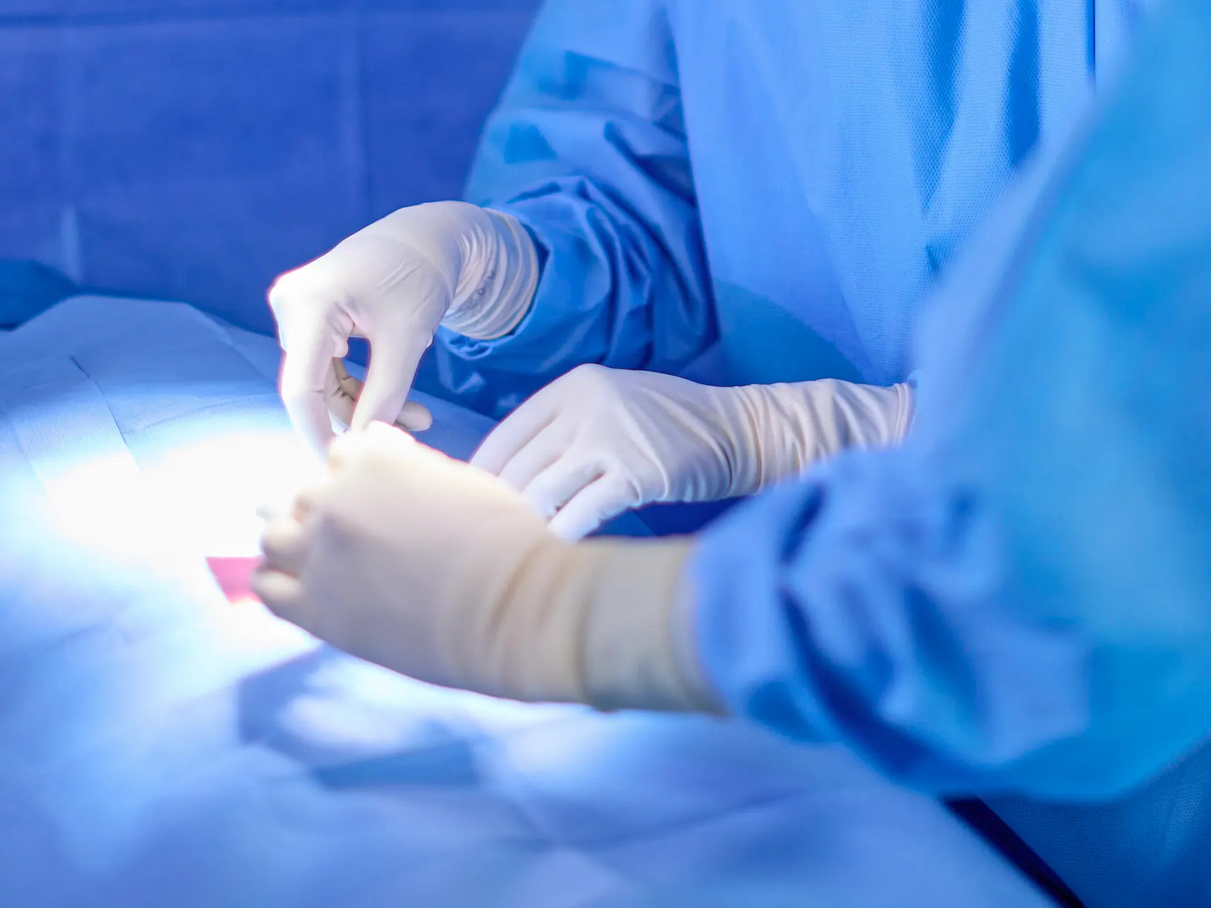 Close up of the hands of surgeons operating on a patient
