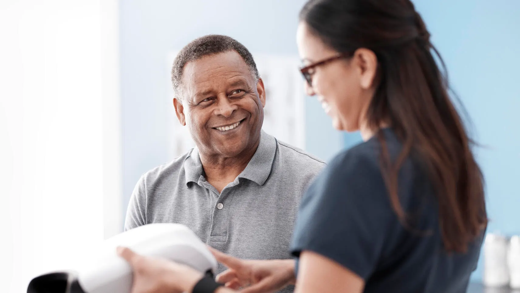 Patient smiles at a healthcare professional looking at the screen of a RetinaVue 700