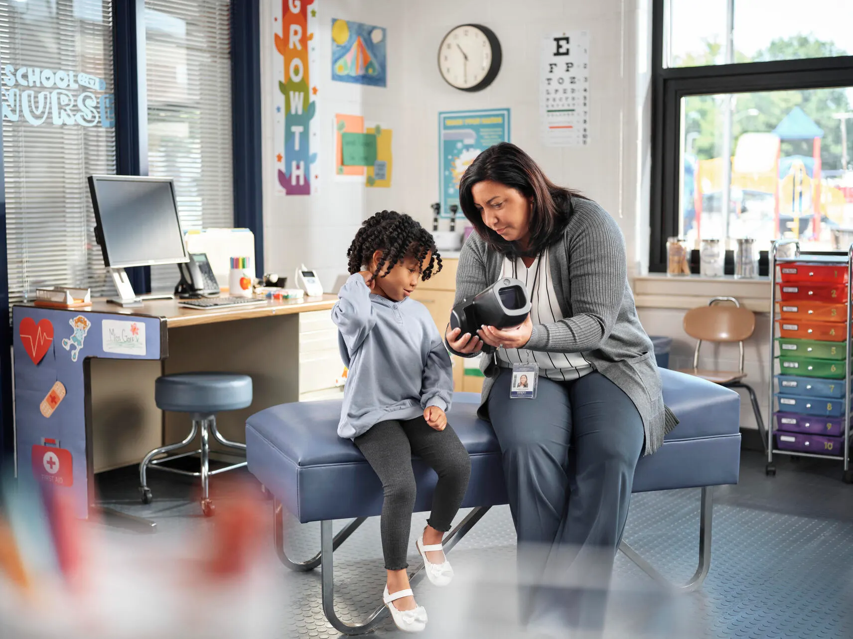 School Nurse shows results of Spot vision screener test to a child