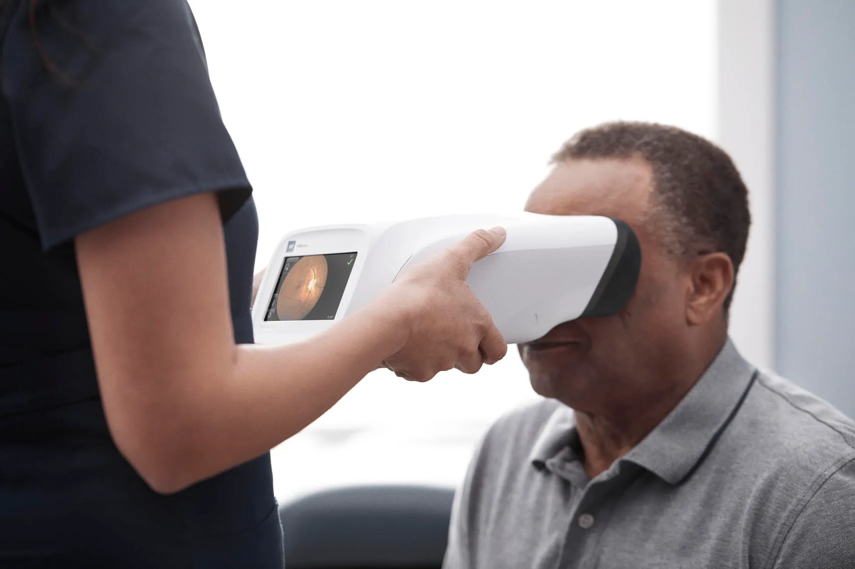 Clinician using the RetinaVue 700 on a patient