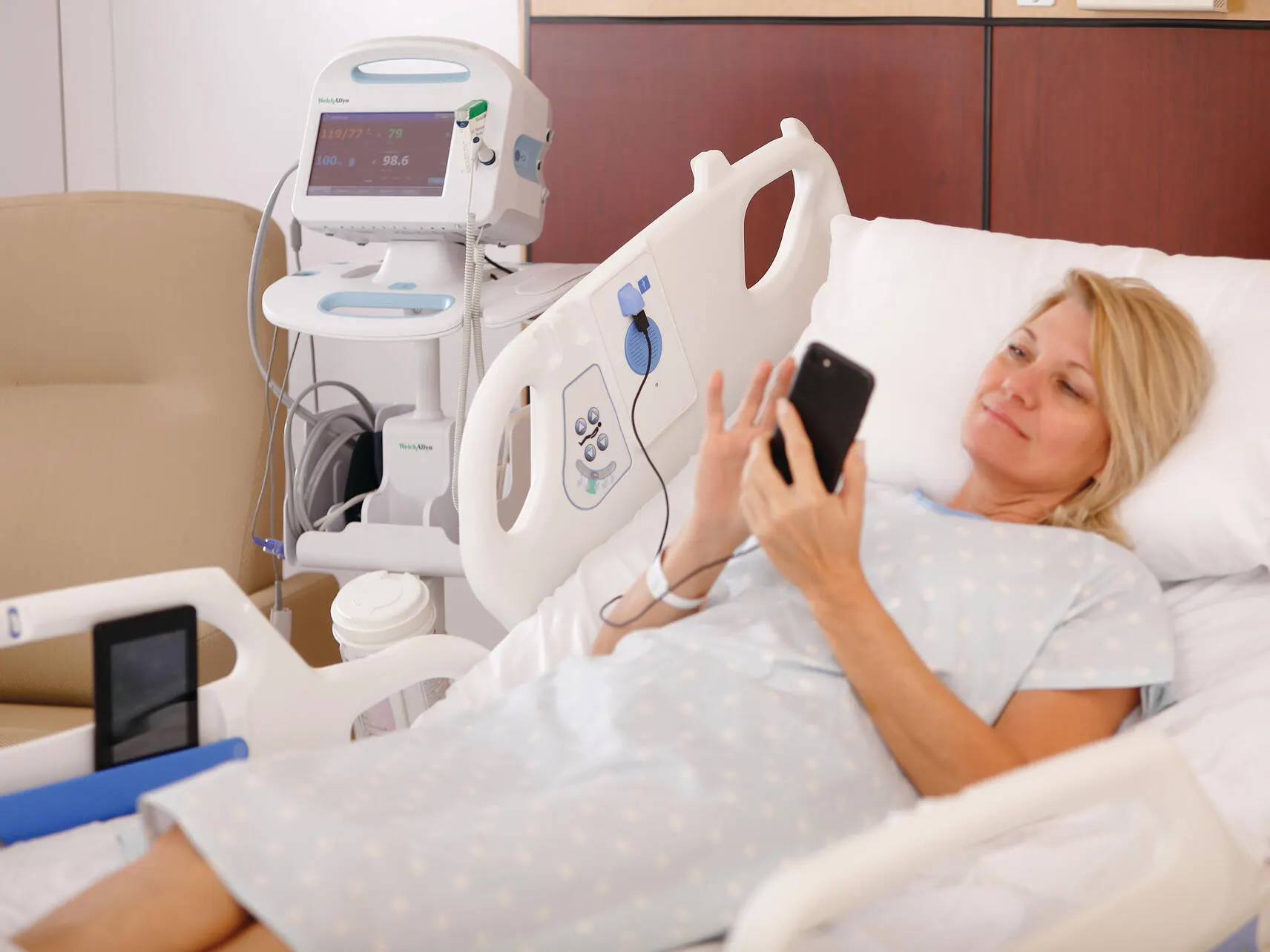 Patient using a mobile phone plugged into a USB charging port in the Centrella bed