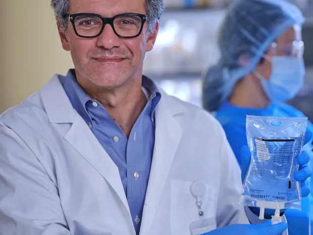 A physician holding up a bag of premixed pharmaceutical injection