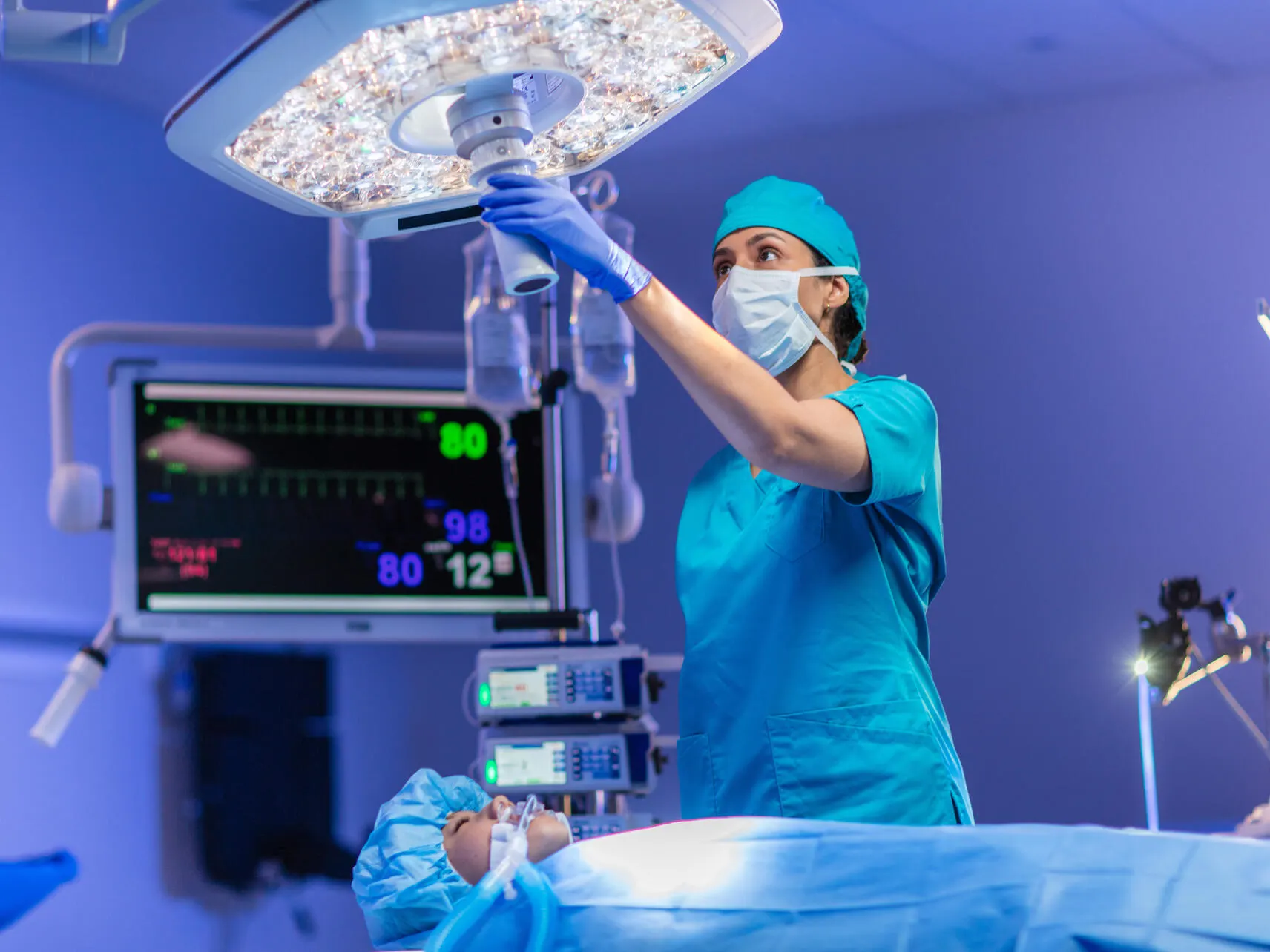 Surgeon in an operating room adjusts Helux Pro surgical light